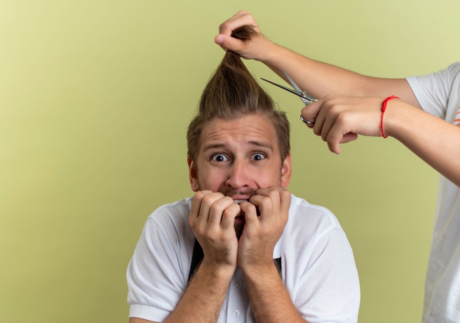Top Tips on Cutting Men’s Hair: A Guide for Beginners & Future Barbers 6 Nervous man biting his nails as someone prepares to cut his hair with scissors, humorous barbershop moment