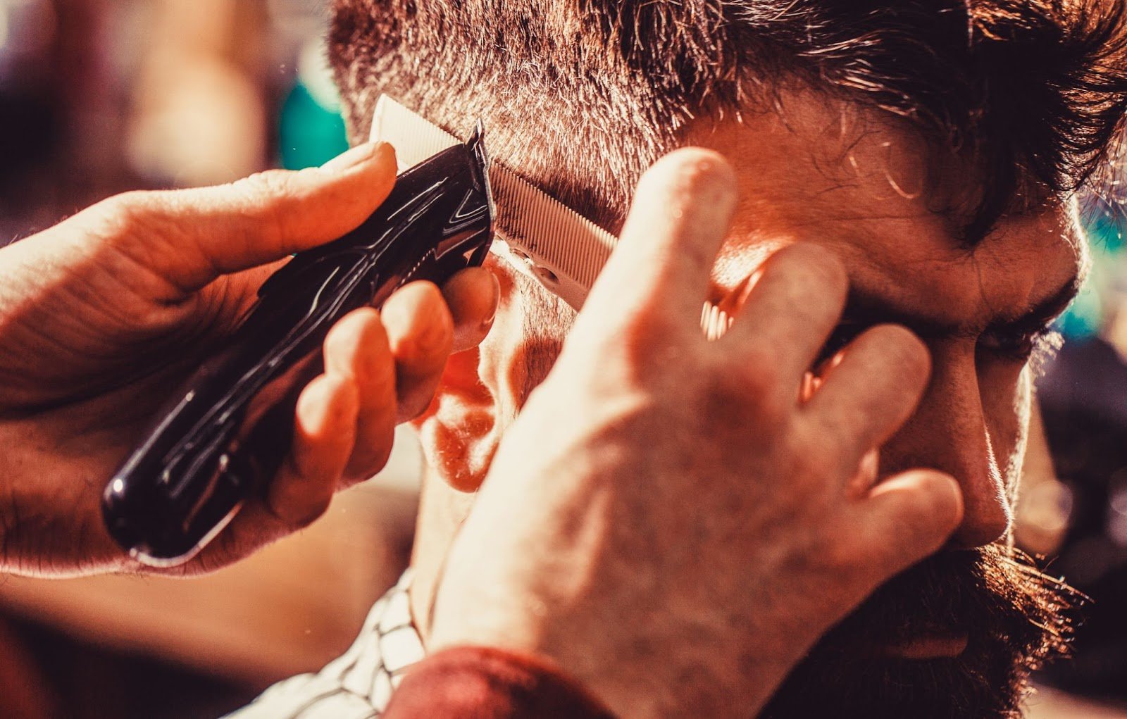 Top Tips on Cutting Men’s Hair: A Guide for Beginners & Future Barbers 1 Close-up of barber using clippers and comb for a precise men’s haircut