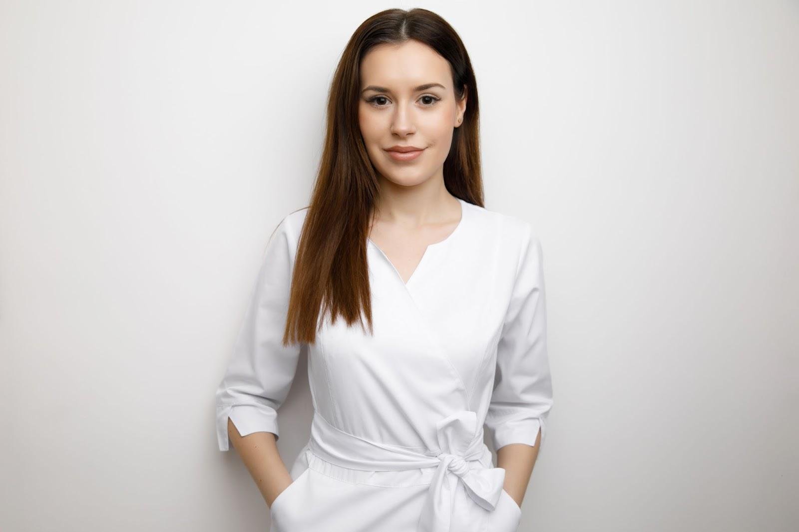 Cosmetology State Board Exam: How to Prepare 5 Portrait of a confident cosmetologist wearing white uniform standing against white background
