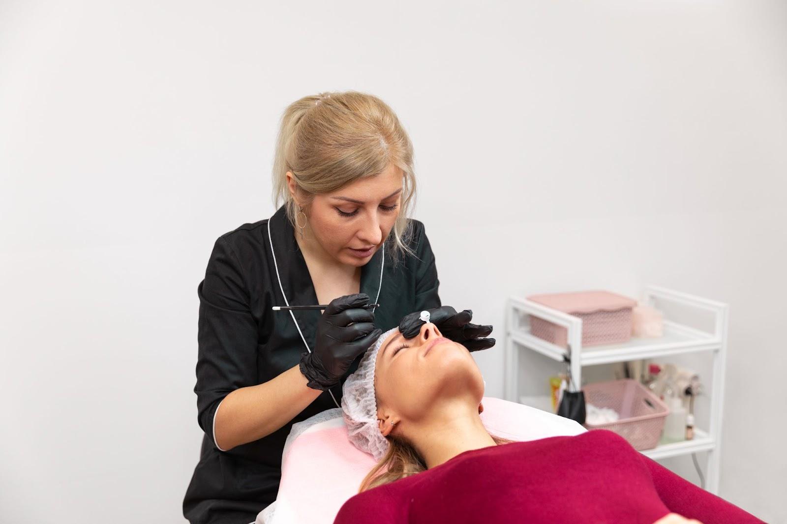Cosmetology State Board Exam: How to Prepare 4 Esthetician performing facial procedure on client in a professional treatment room