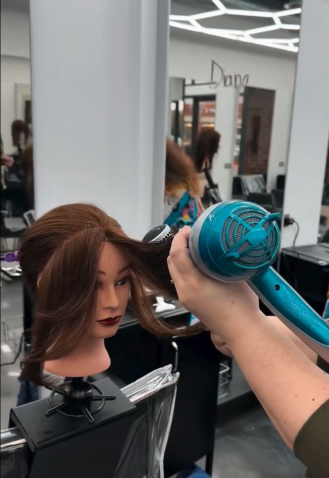 How to Become a Cosmetologist in Illinois: Complete 2025 Guide 5 Doing hair dryer on a doll head while training.