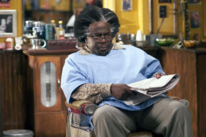 Cedric the Entertainer as Eddie reading newspaper in Barbershop film