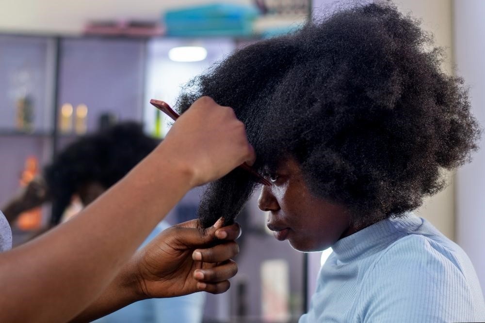 Cosmetology student styling natural curly hair.