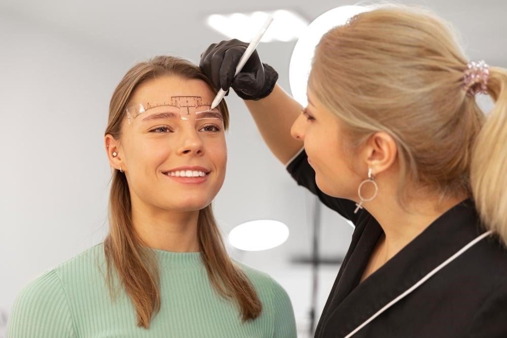 Certified brow technician working on a client at a salon.