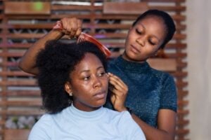 Student learning how to style African hair at cosmetology school.