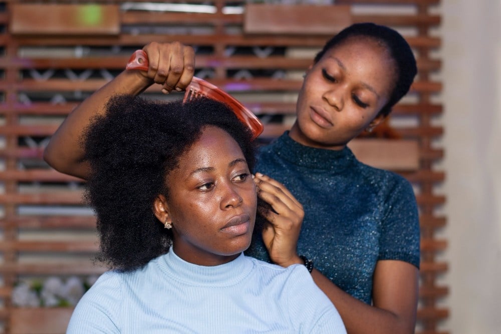 Student learning how to style African hair at cosmetology school.