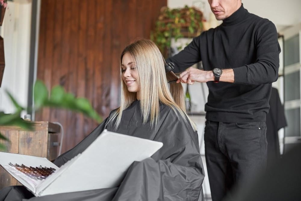 Hairstylist working on a female client's hair.
