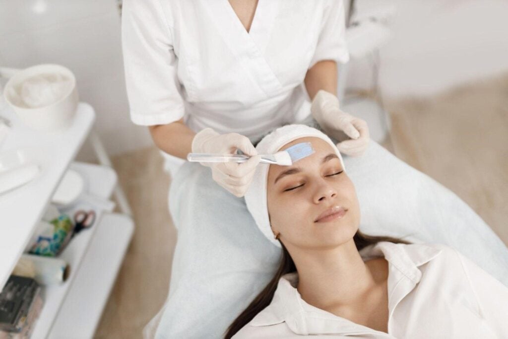 Esthetician performing a facial on a client.