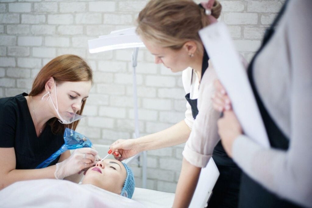 Esthetician school students practicing doing skincare services on a client.