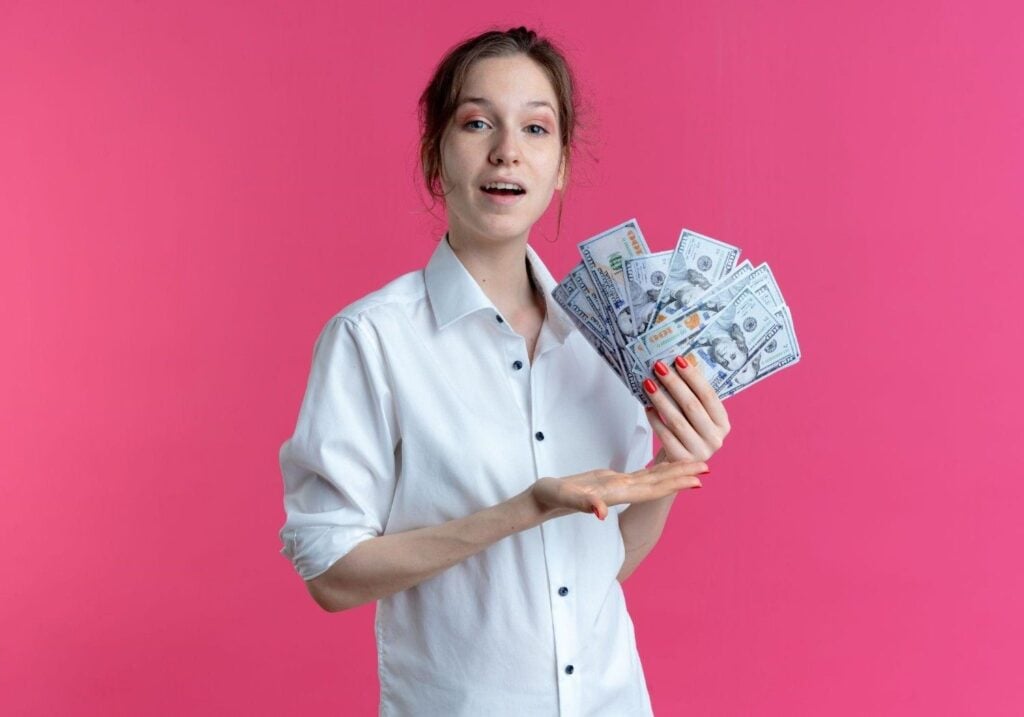 Esthetician holding money, illustrating their earnings as an esthetician.