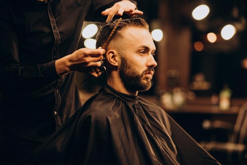 Student practicing fades at a barber school in Illinois