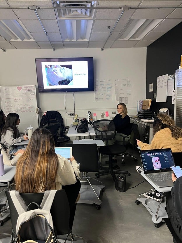 Esthetics students attending a esthetics classroom lesson on professional skincare for diverse skin conditions at Cosmetology & Spa Academy.