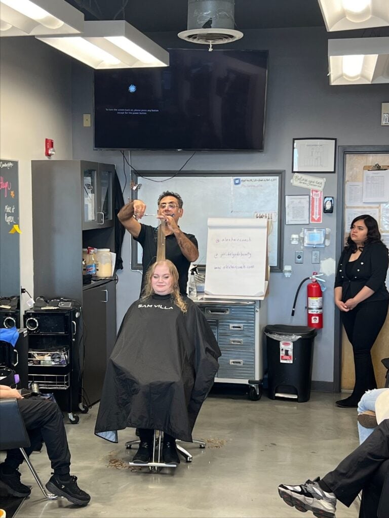 Barber demonstrating haircut techniques.