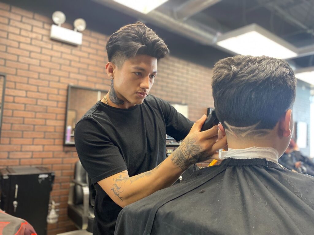 Barber cutting hair in salon.