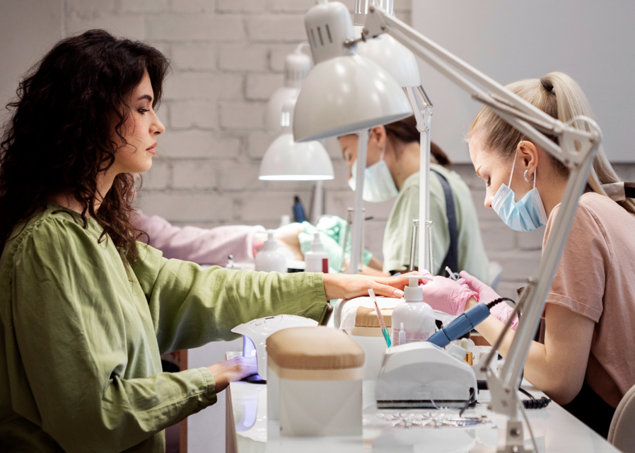 People getting manicures in salon.