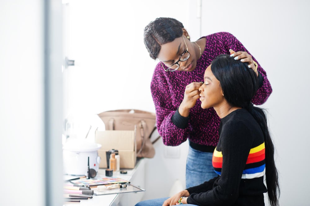 cosmetology student practicing on a client during their makeup school training