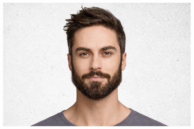 Man with a well-groomed full beard and styled hair demonstrating a classic beard style for men.