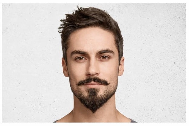 Man with a styled goatee beard demonstrating a defined beard shape for men’s grooming.