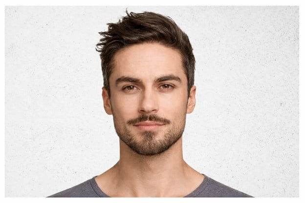 Male model with short stubble beard showing a clean and modern beard style.