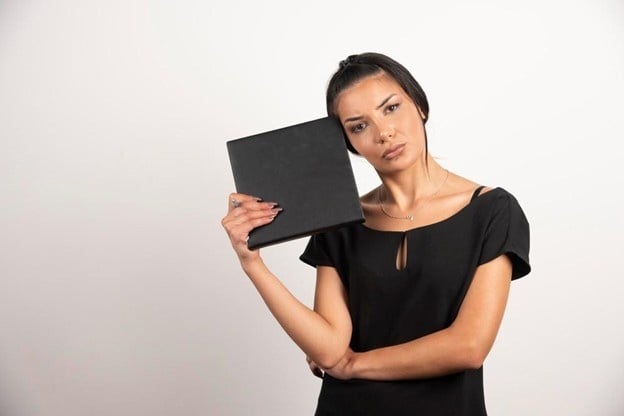 Beauty model holding makeup palette for a professional makeup portfolio photo for cosmetology students.