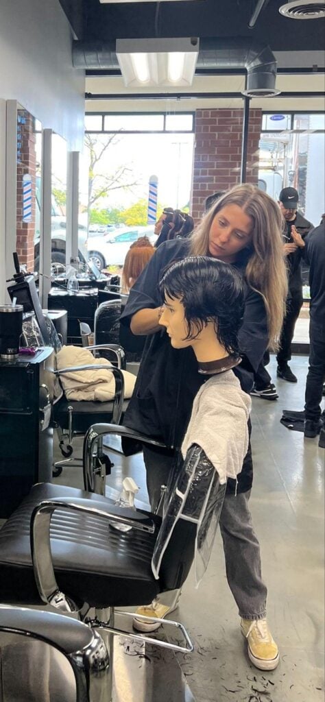 student practicing hair cutting techniques at Cosmetology & Spa Academy, one of the best cosmetology schools in Illinois
